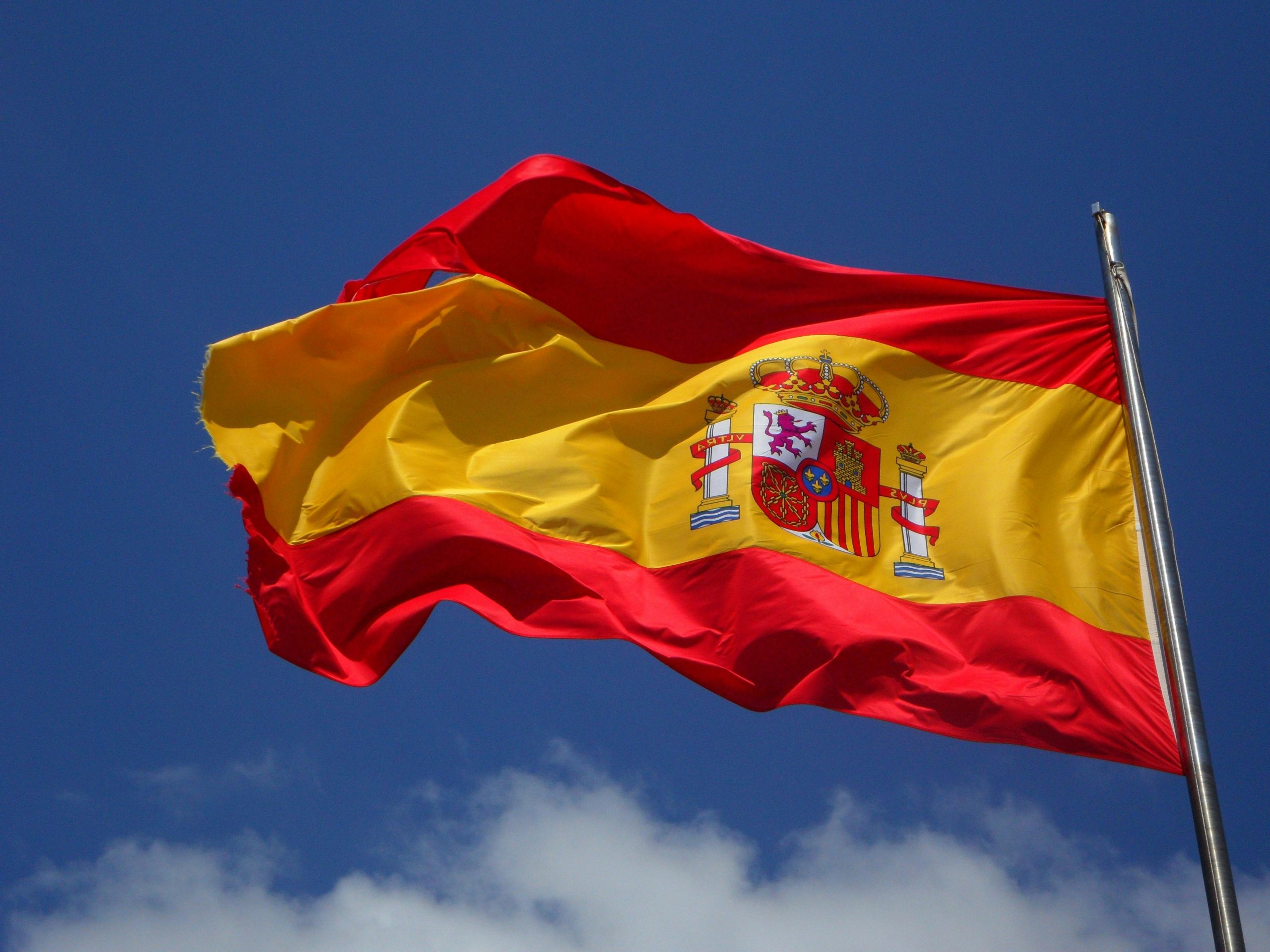 Bandera de España ondeando, simbolizando las oportunidades para la organización de reuniones, networking y eventos.